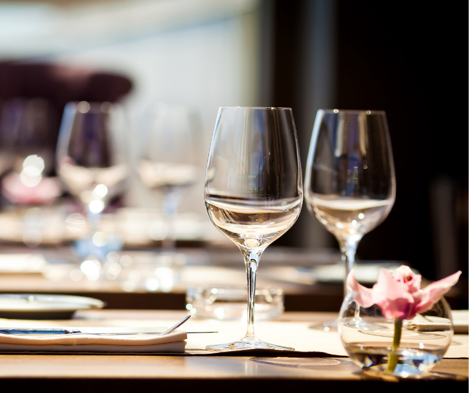 2 wine glasses with white wine on a laid wooden table.